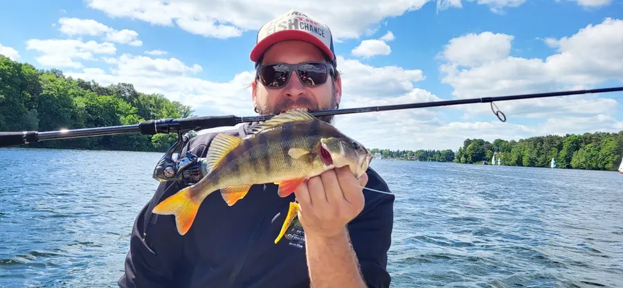Andreas Kliem mit einem Barsch auf dem Wasser